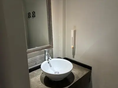a bathroom with a white bowl sink on a counter at Cacha Hotel in Bangkok
