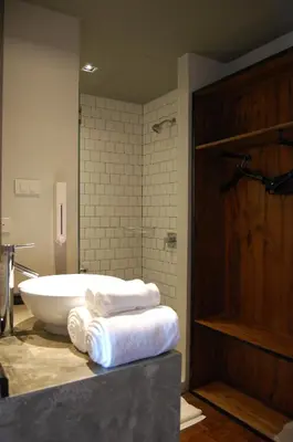 a bathroom with a tub and towels on a counter at Cacha Hotel in Bangkok
