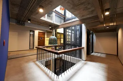 a hallway with a staircase in a building at Cacha Hotel in Bangkok