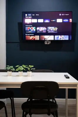 a table with chairs and a tv on a wall at A4 Cosy Twin large beds - Silom in Bangkok