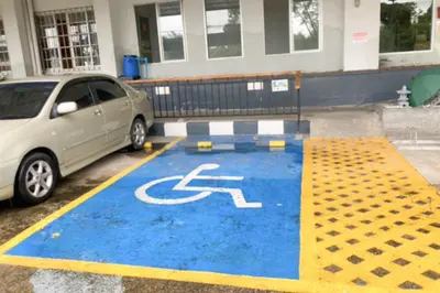 a car parked in a parking lot with a handicapped sign at L'Hotel Bangkok in Bangkok
