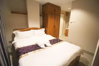 a bedroom with a bed with towels on it at L'Hotel Bangkok in Bangkok