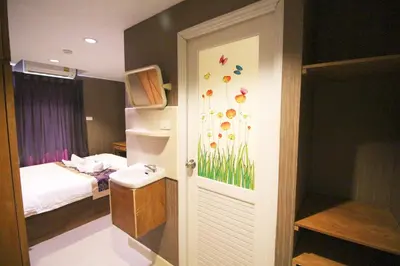 a bathroom with a sink and a bedroom with a bed at L'Hotel Bangkok in Bangkok