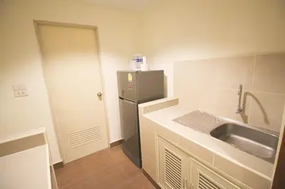 a small kitchen with a sink and a refrigerator at L'Hotel Bangkok in Bangkok