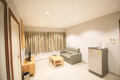 a living room with a chair and a television at L'Hotel Bangkok in Bangkok