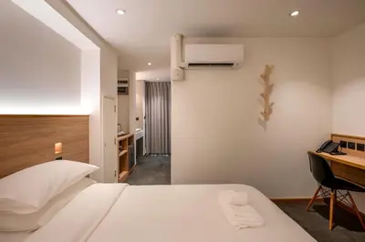 a bedroom with a white bed and a desk and a desk at ZEN MASTER HOTEL in Bangkok
