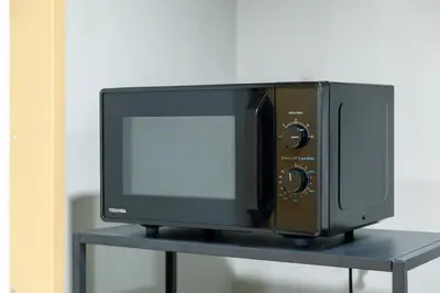 a microwave oven sitting on top of a shelf at Nishitetsu Hotel Croom Bangkok Silom in Bangkok