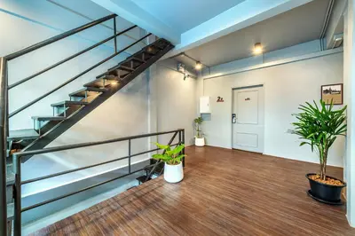an empty room with stairs and potted plants at Ti Thong Hostel in Bangkok