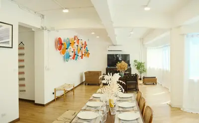 a long dining room with white tables and chairs at Private Full-Floor Spacious 5BR in China Town in Bangkok