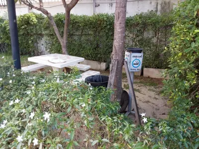 a picnic table next to a tree and a trash can at Sukhumvit​ 101 in Phra Khanong