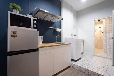 a kitchen with white cabinets and a refrigerator at A2 Comfortable space wt Kitchen in Bangkok