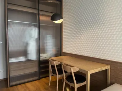 a dining room with a wooden table and two chairs at Luxurious Apartment in Sukhumvit in Bangkok
