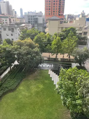 a park with white benches and trees in a city at Luxurious Apartment in Sukhumvit in Bangkok