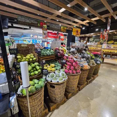 a produce section of a grocery store with baskets of fruit at Unplugged at Bangrak Design Hostel in Bangkok