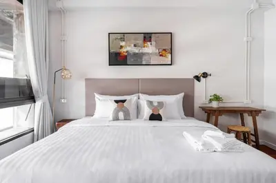 a bedroom with a white bed with twoeddy bears on it at Unplugged at Bangrak Design Hostel in Bangkok