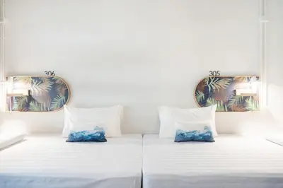 two beds in a room with two mirrors at Unplugged at Bangrak Design Hostel in Bangkok