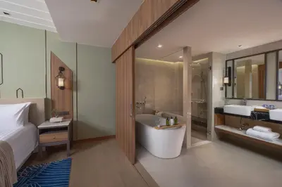 a bathroom with a bed and a tub and a sink at Nysa Hotel Bangkok Sukhumvit 11 in Bangkok