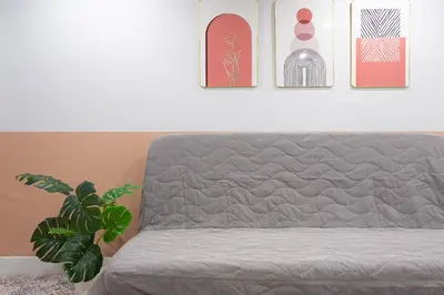 a gray couch in a room with a plant at A1 Duplex large room wt kitchen in Bangkok