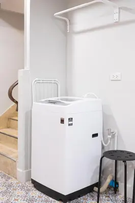 a white refrigerator in a room with a stool at A1 Duplex large room wt kitchen in Bangkok