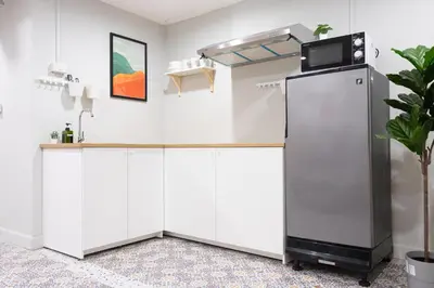 a kitchen with white cabinets and a refrigerator at A1 Duplex large room wt kitchen in Bangkok