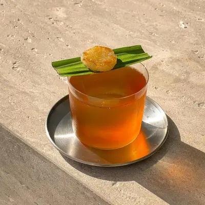 a drink on a plate on a table at Saan Hotel Sathorn in Bangkok