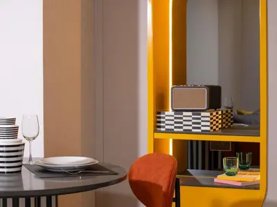 a dining room with a table and a radio on a shelf at TRIBE Living Bangkok Sukhumvit 39 by AccorHotels in Bangkok