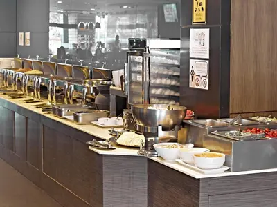 a buffet line in a restaurant with plates of food at Bangkok City Hotel in Bangkok