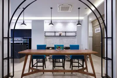 a dining room with a wooden table and blue chairs at Alpine Boutique Pratunam in Bangkok