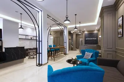 a living room with a blue couch and a table at Alpine Boutique Pratunam in Bangkok