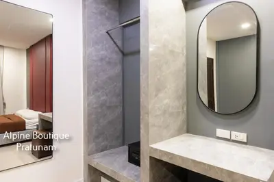 a bathroom with a mirror and a sink at Alpine Boutique Pratunam in Bangkok
