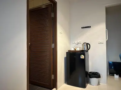 a room with a refrigerator and a wooden door at Narastay @ Phrom Phong in Bangkok
