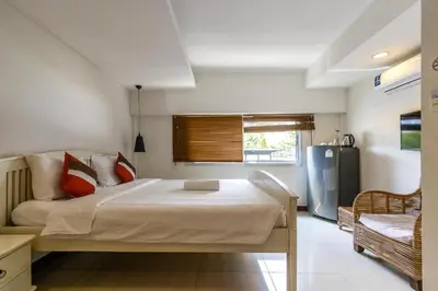 a bedroom with a large bed and a refrigerator at Narastay @ Phrom Phong in Bangkok