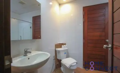 a bathroom with a sink and a toilet and a mirror at Lasalle Park Serviced Apartment at Lasalle 75 in Bangna