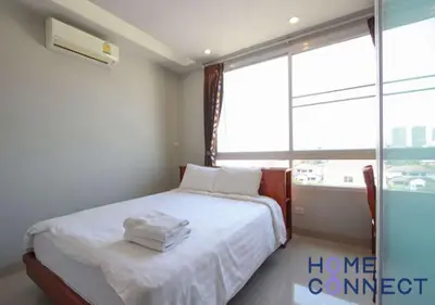 a bedroom with a bed with white sheets and a window at Lasalle Park Serviced Apartment at Lasalle 75 in Bangna