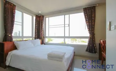 a bedroom with a bed and a large window at Lasalle Park Serviced Apartment at Lasalle 75 in Bangna