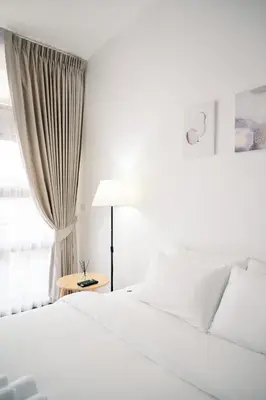 a white bedroom with a bed and a lamp at Mitt Haus (Lat Phrao Soi 5) in Bang Su