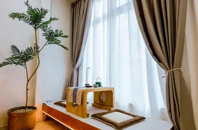 a room with a table and a tree in front of a window at Ratchada Retreat Bespoke Urban Villa 3 in Bangkok