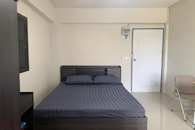 a bedroom with a bed with blue sheets and a chair at Na Nont Place in Bangkok