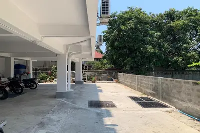 a building with a motorcycle parked next to a wall at Na Nont Place in Bangkok