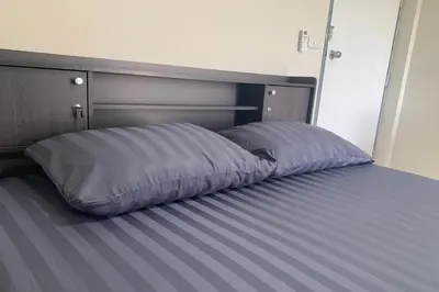 a bed with a pillow on it in a room at Na Nont Place in Bangkok