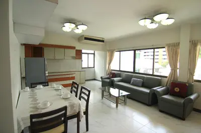 a kitchen and living room with a table and a couch at Manoo House H in Makkasan
