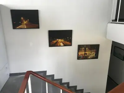 three pictures hanging on a wall with a staircase at Manoo House H in Makkasan