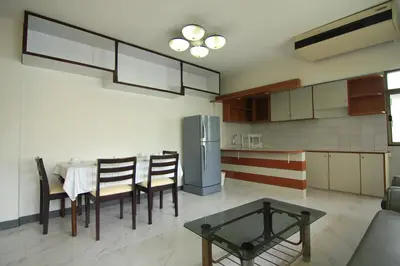a kitchen with a table and chairs and a refrigerator at Manoo House H in Makkasan