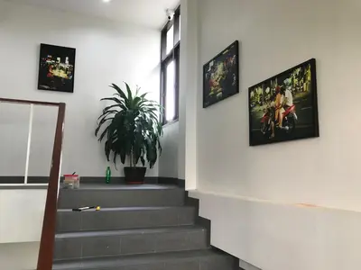 a staircase with pictures on the wall and a plant at Manoo House H in Makkasan