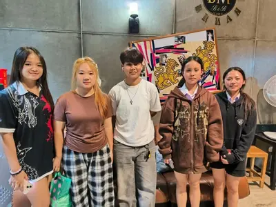 a group of children standing in front of a painting at Hostel Bangkok BM B&B in Bangkok