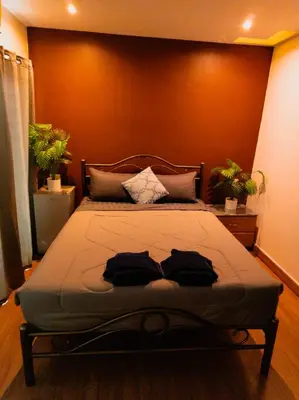 a bedroom with a bed with an orange wall at Hostel Bangkok BM B&B in Bangkok