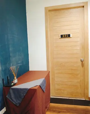 a room with a table and a door with a sign on it at BM Loft On Nut & Massage in Bangkok