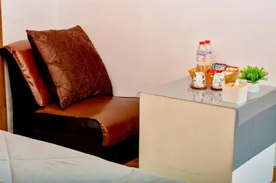 a chair sitting next to a table with bottles of water at BM Loft On Nut & Massage in Bangkok