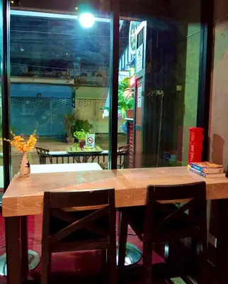 a wooden table with two chairs and a window at BM Loft On Nut & Massage in Bangkok