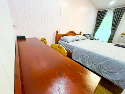 a bedroom with a bed and a wooden table at Number9 Bangkoknoi BKK Homestay in Bangkok